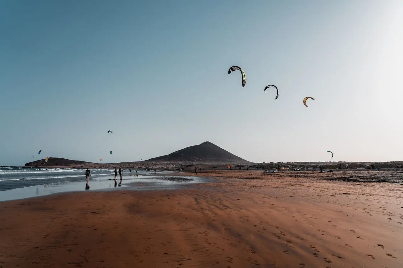 Kitesurfers op het strand van El Médano met Montaña Roja
